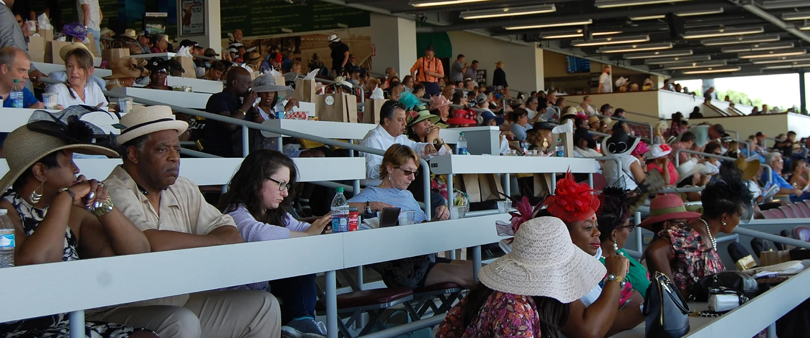 Spectators seated at tiered covered counters at Sam Houston Race Park